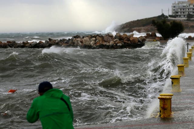 A man takes a photograph during bad weather at the port of Rafina, east of Athens