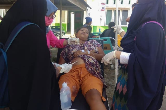 Authorities treat a woman on the Indonesian island of Sulawesi following the earthquake