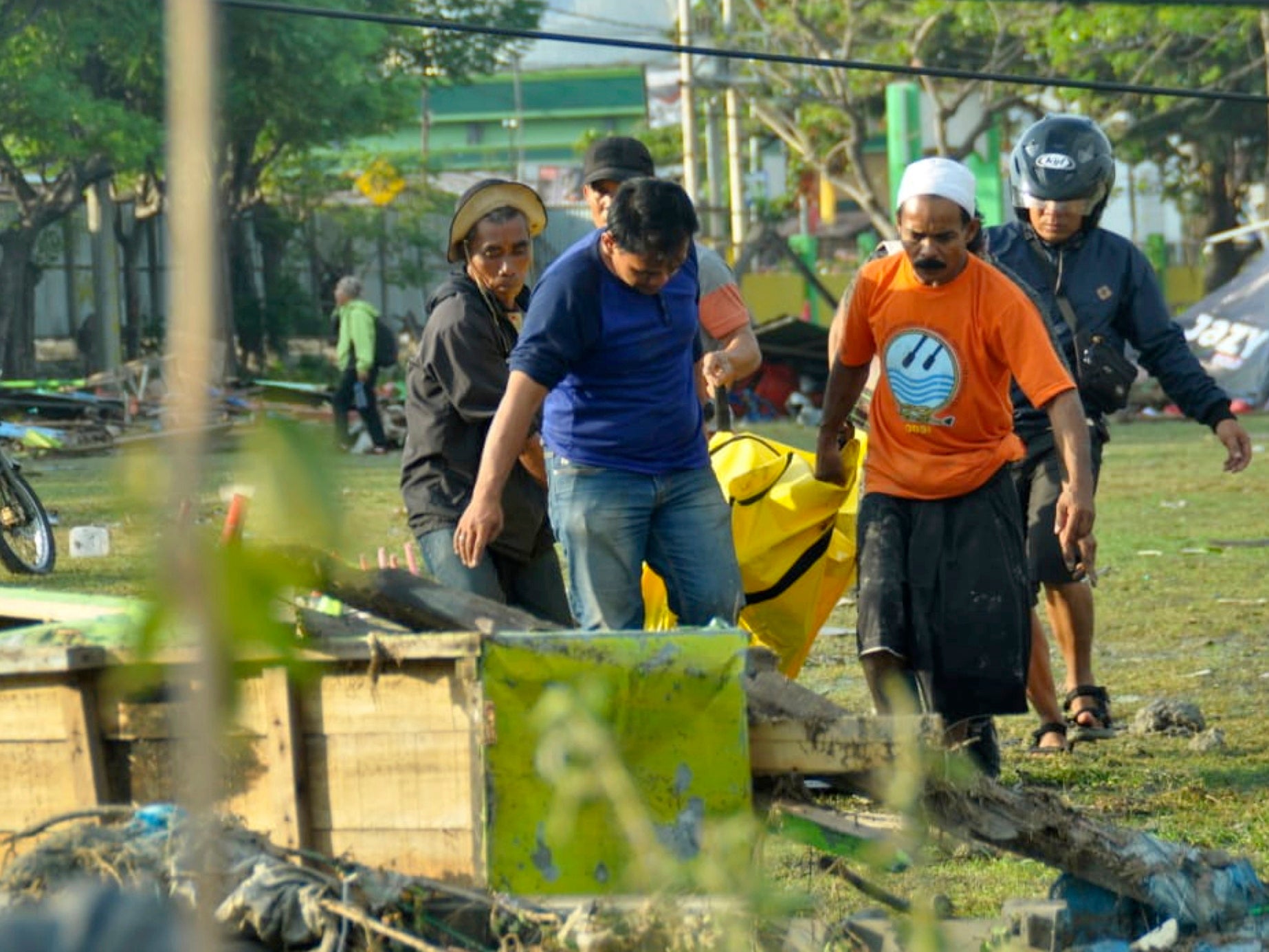 Residents carry a quake victim through Palu