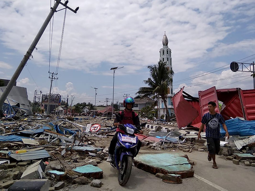 Residents make their way along a street full of debris after an earthquake and tsunami hit Palu, on Sulawesi (AFP/Getty )