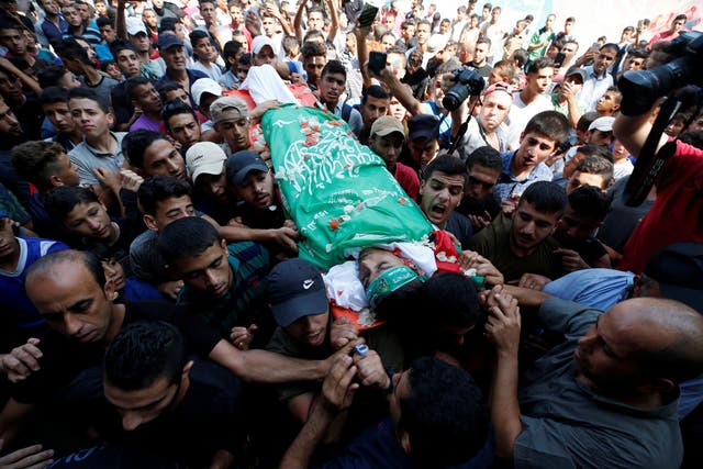 Mourners carry the body of Palestinian boy Mohammed al-Hoam, 14, who was killed at the Israel-Gaza border fence.