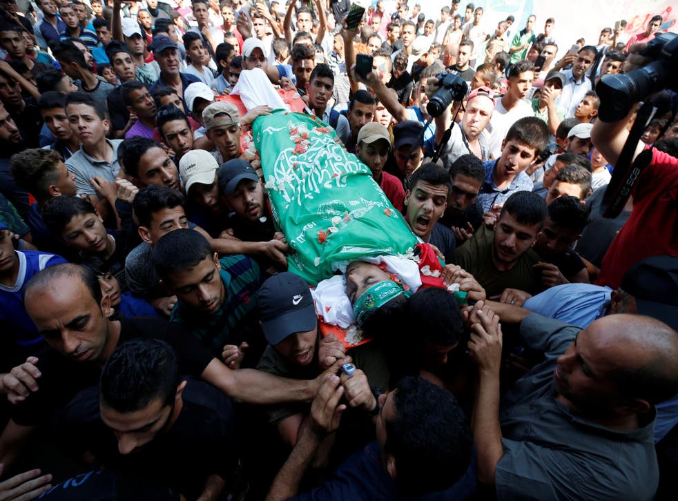 Mourners carry the body of Palestinian boy Mohammed al-Hoam, 14, who was killed at the Israel-Gaza border fence.