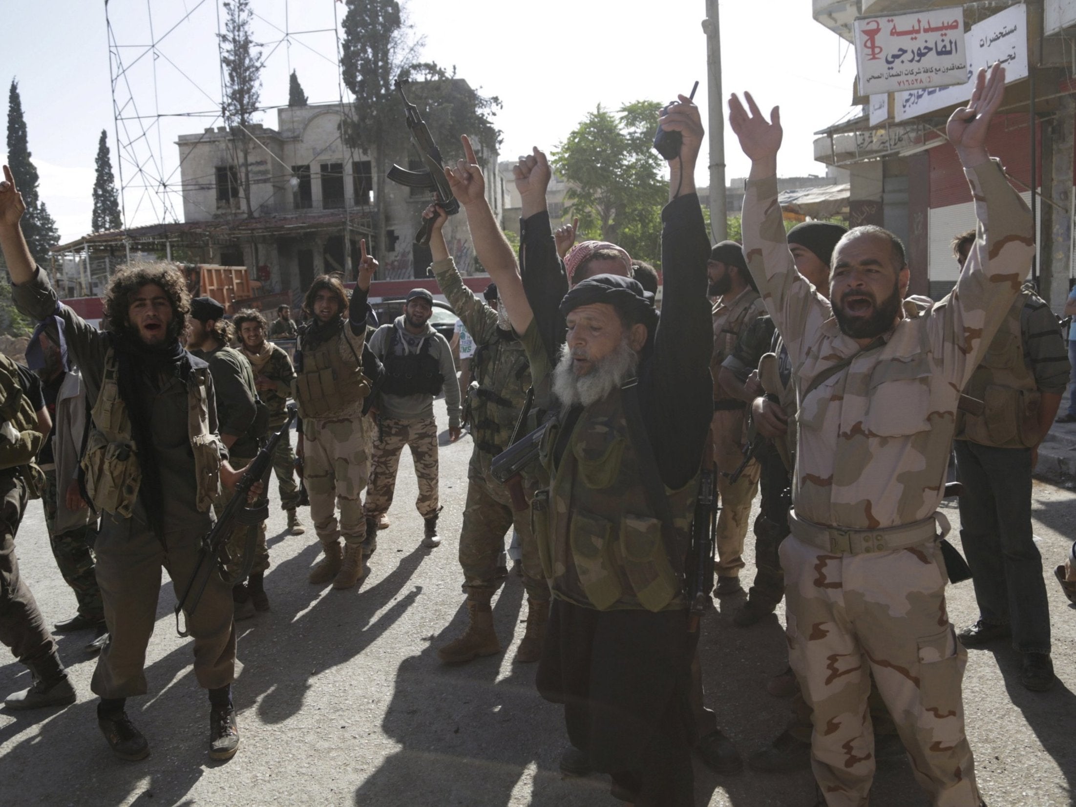 Members of the former al-Qaeda affiliate in Syria, now called Hayat Tahrir al-Sham, gesture as they cheer in the northwestern city of Ariha, after a coalition of insurgent groups seized the area in Idlib province on 29 May 2015