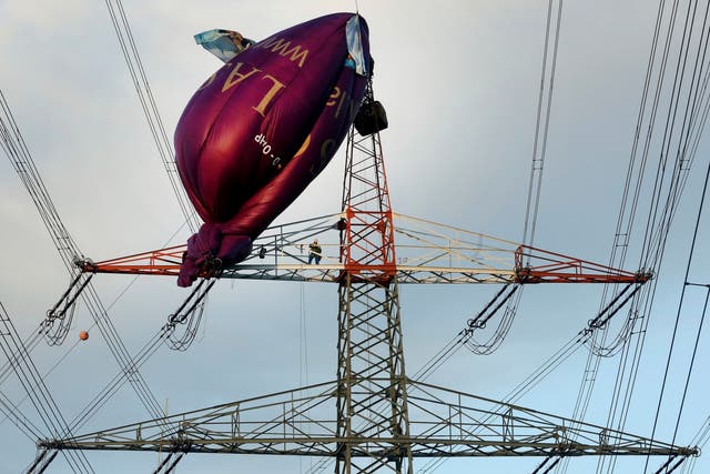 A hot air balloon hangs on top of a high-voltage power line in Bottrop