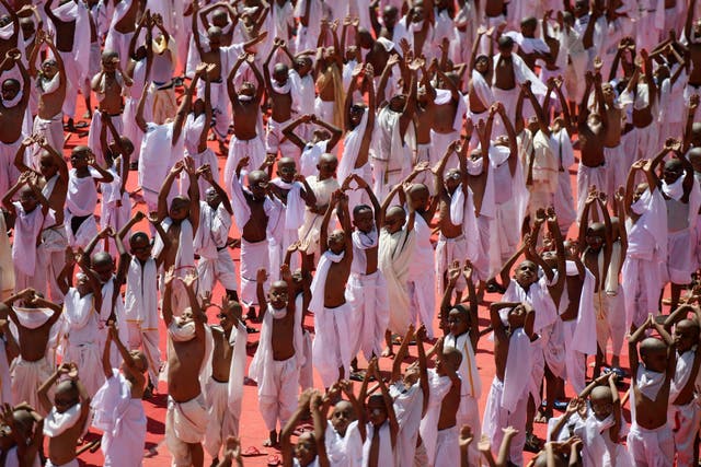 Indian school children dressed like Mahatma Gandhi perform yoga during an event at a school in Chennai