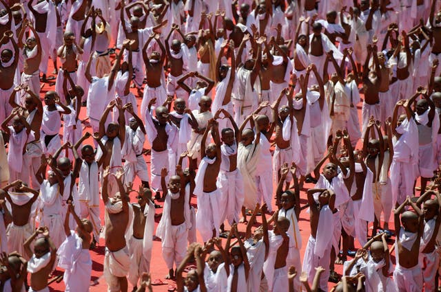 Indian school children dressed like Mahatma Gandhi perform yoga during an event at a school in Chennai