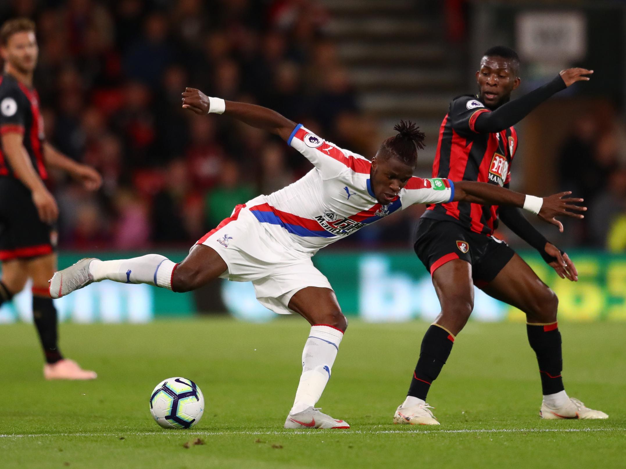 Wilfried Zaha battles for possession with Jefferson Lerma