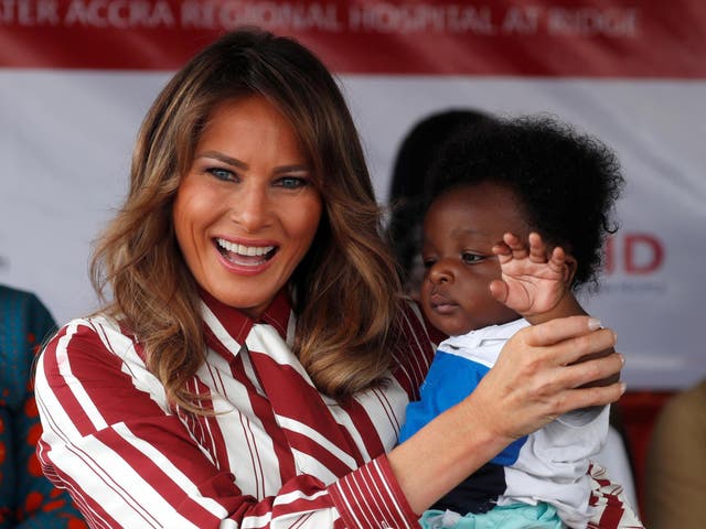 Melania Trump holds a child during a visit to a hospital in Accra