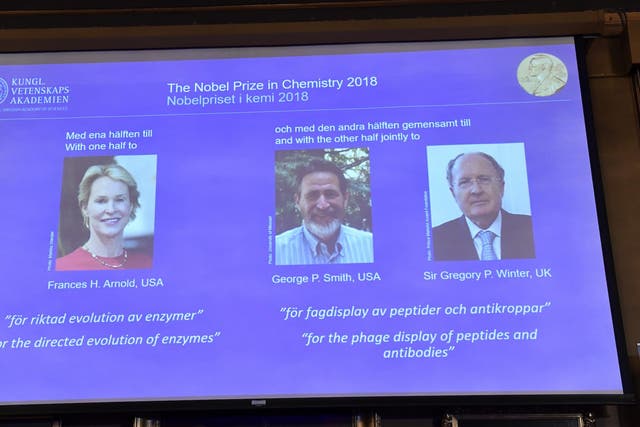 A screen displays portraits of Frances H Arnold of the United States, George P Smith of the United States and Gregory P Winter of Great Britain during the announcement of the winners of the 2018 Nobel Prize in Chemestry at the Royal Swedish Academy of Sciences on October 3, 2018 in Stockholm