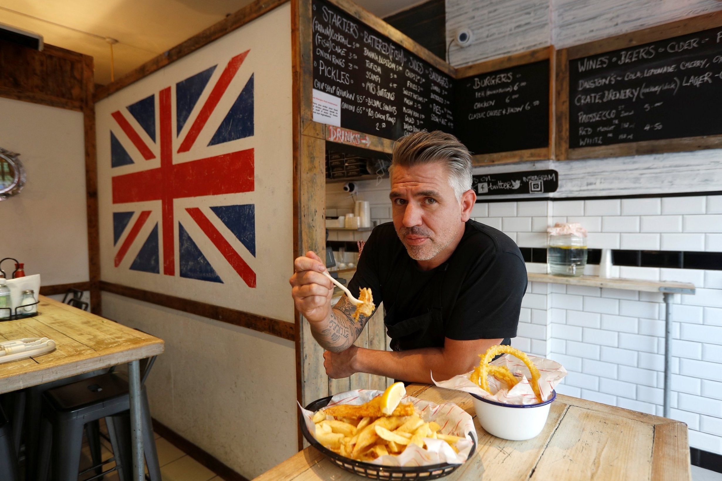 Restaurant owner Daniel Sutton poses for a photograph at his establishment in Hackney, London.