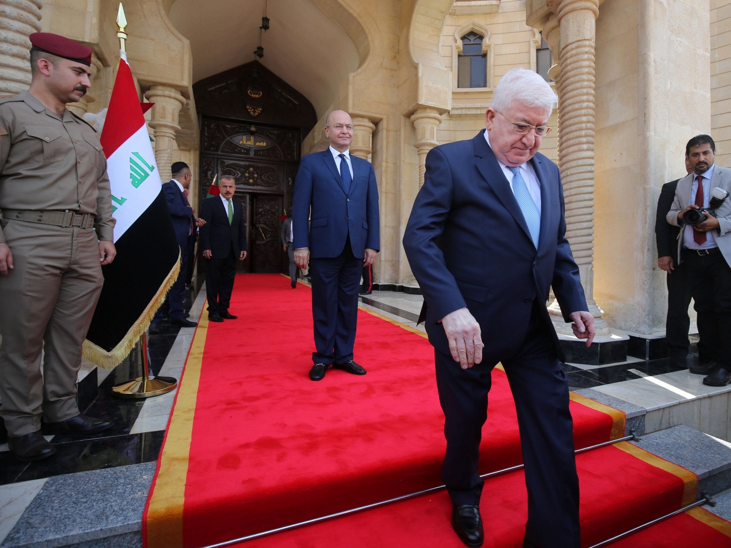 Iraq’s newly elected president, Kurdish politician Barham Salih (centre), watches on as his predecessor Fuad Masum leaves during the handing-over ceremony in Baghdad on Wednesday