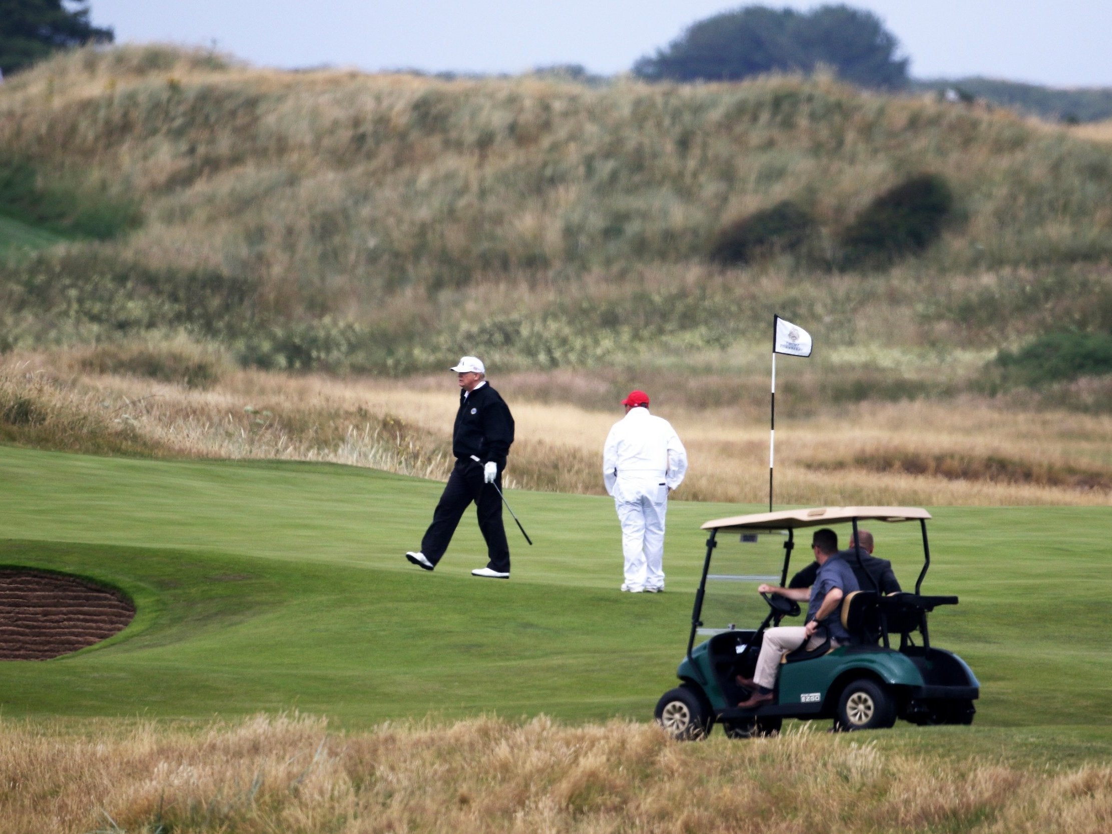 Donald Trump walks off the 4th green while playing at Turnberry golf club