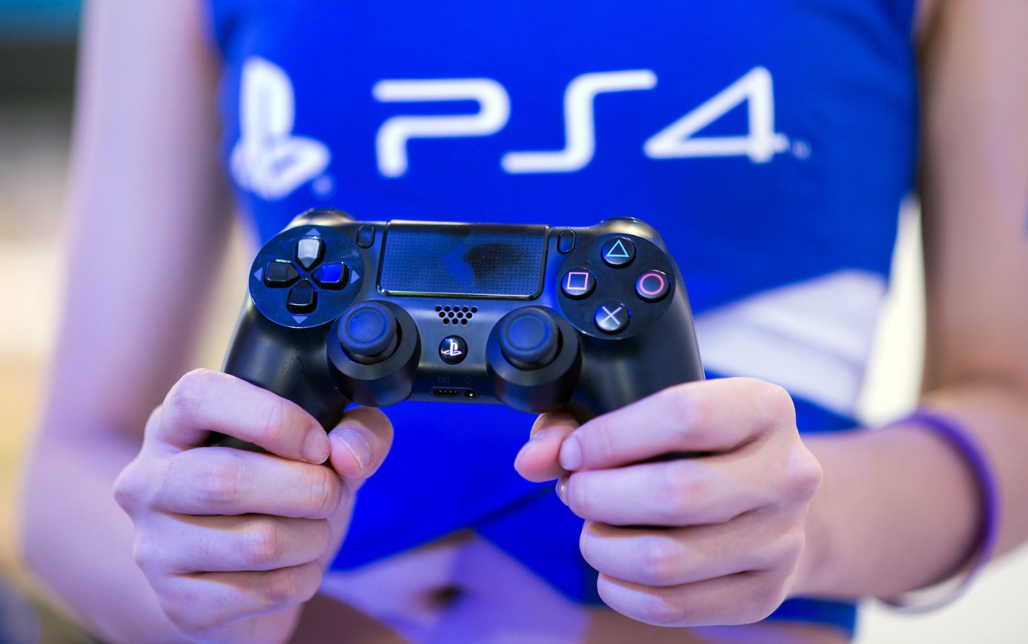 A hostess holds a remote of a Playstation 4 at the Sony booth during the China Joy fair in Shanghai