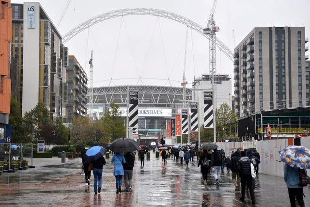 People shelter from the rain before the match between Tottenham Hotspur and Cardiff City