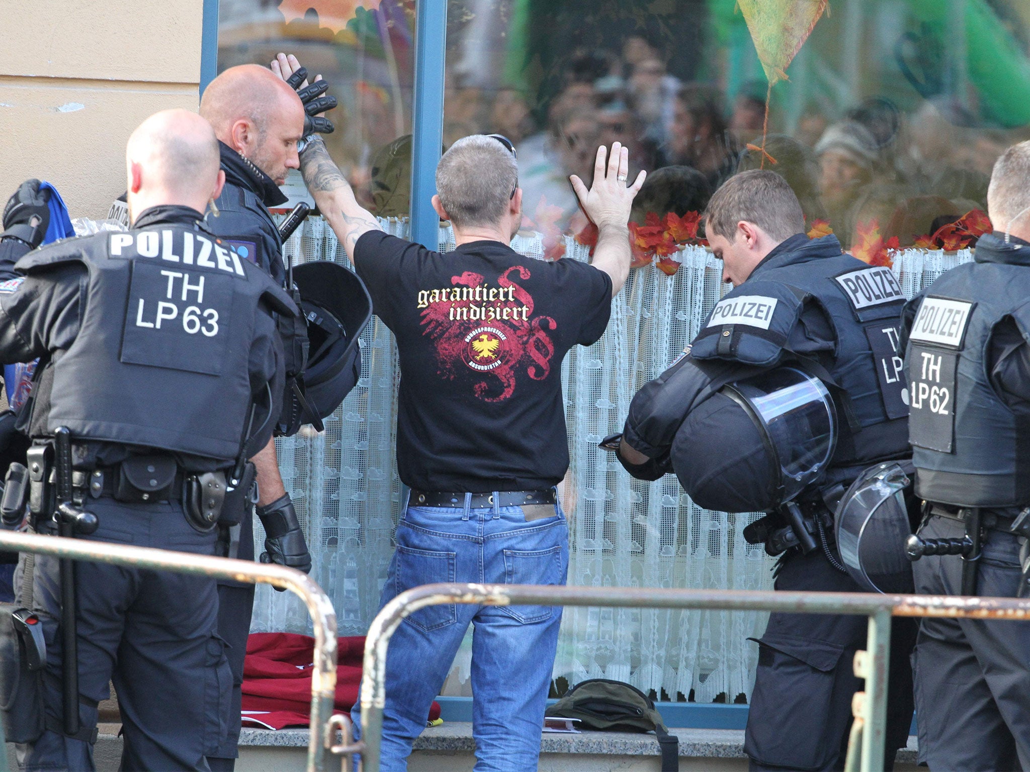 A concert attendee is searched by police ahead of the far-right event in the central German town of Apolda on Saturday