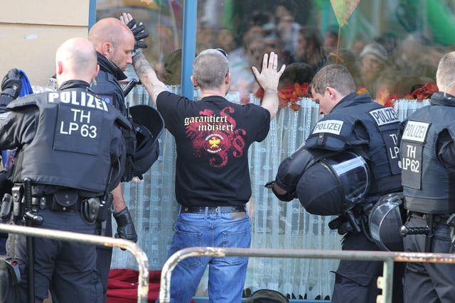 A concert attendee is searched by police ahead of the far-right event in the central German town of Apolda on Saturday