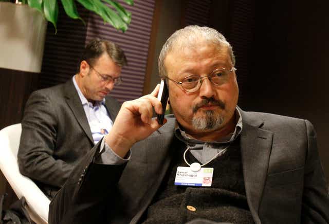 In this January 29, 2011 file photo, Saudi journalist Jamal Khashoggi speaks on his cellphone at the World Economic Forum in Davos, Switzerland. Khashoggi was a Saudi insider