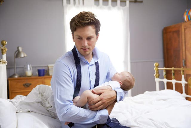 Stressed Father Dressed For Work Holding Baby In Bedroom