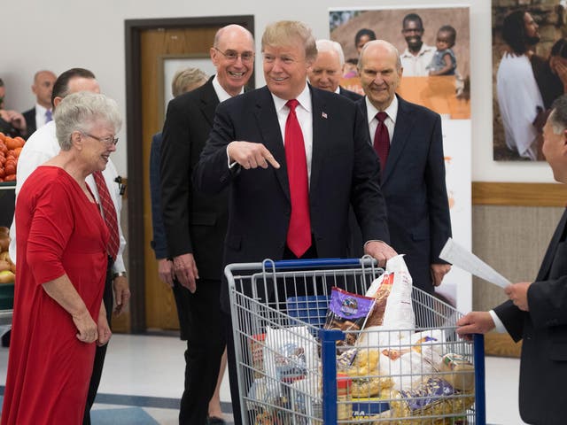 US President Donald Trump pushes a shopping cart as he tours the Church of Jesus Christ of Latter-Day Saints' food distribution centre at Salt Lake City, Utah in December 2017