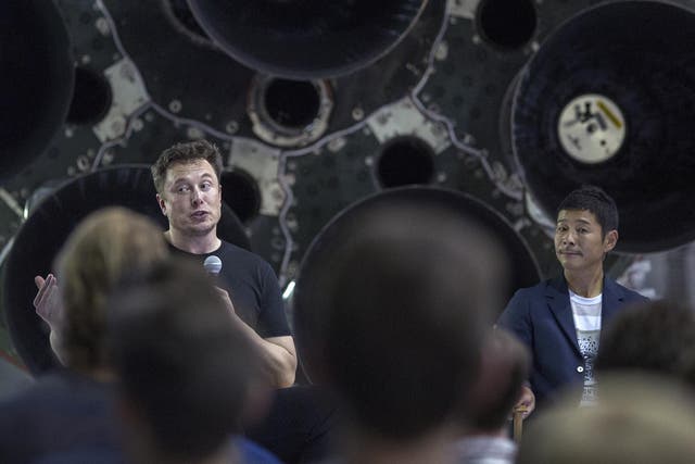 Elon Musk (L) and Japanese billionaire Yusaku Maezawa speak before a Falcon 9 rocket during the announcement that Maezawa will be the first private passenger who will fly around the Moon