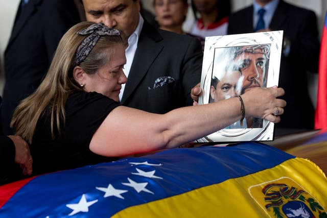 Luz Alban, the sister of opposition activist Fernando Alban places a framed portrait of her brother