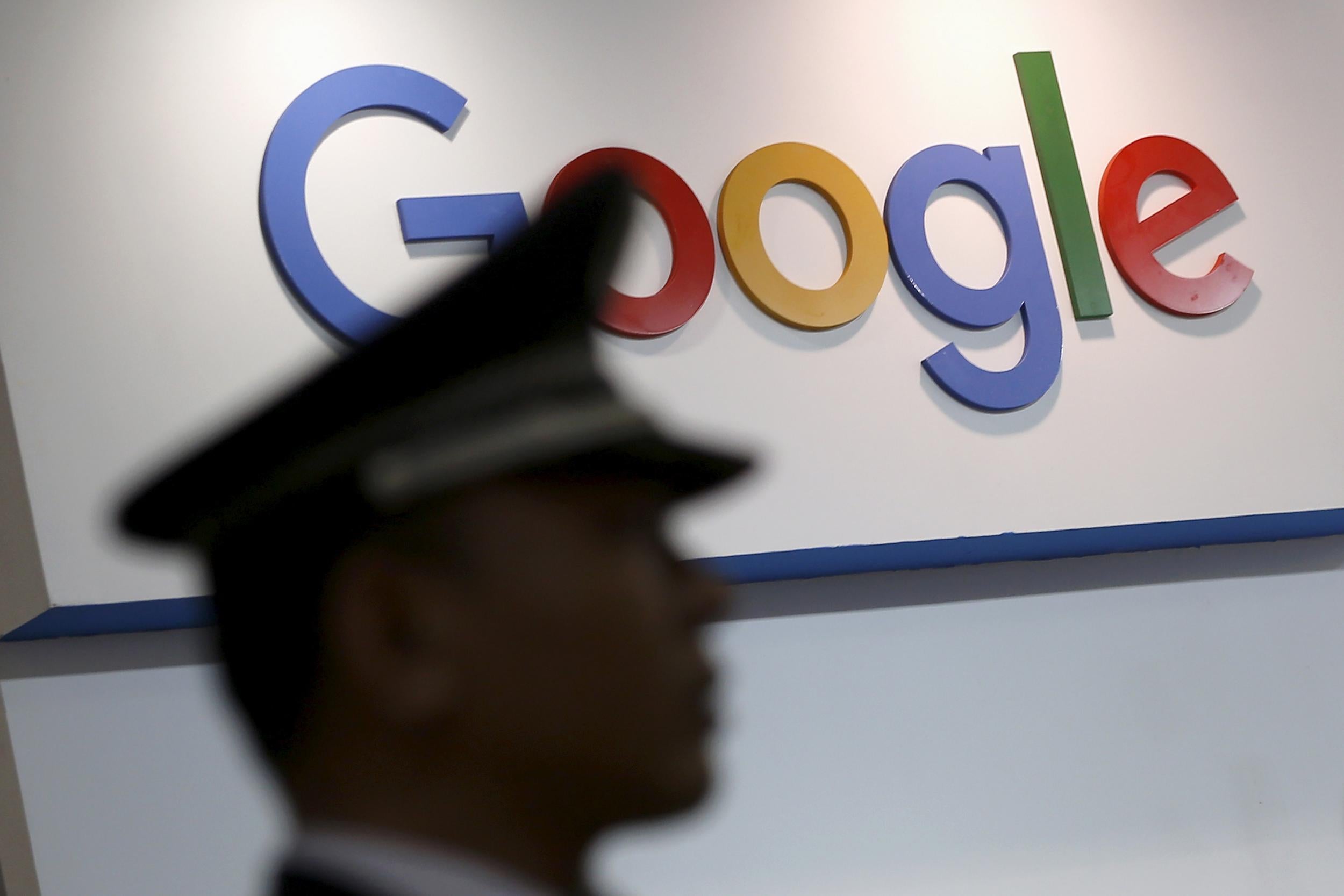 A security guard walks past a logo of Google at a technology fair in Shanghai, China, April 21, 2016