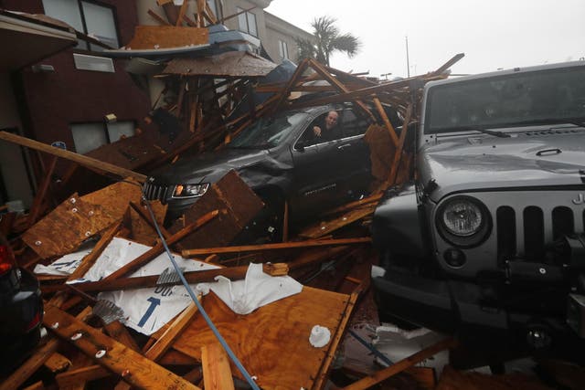 A storm chaser climbs into his vehicle during the eye of Hurricane Michael to retrieve equipment after a hotel canopy collapsed in Panama City Beach, Florida on 10 October 2018.