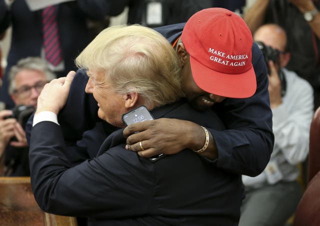 Kanye West hugs Donald Trump during a meeting in the Oval office of the White House