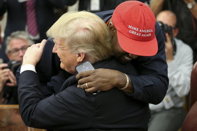 Kanye West hugs Donald Trump during a meeting in the Oval office of the White House