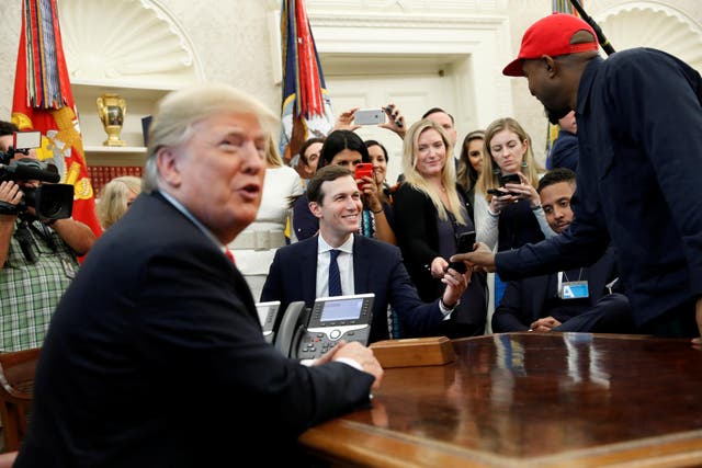 <p>Rapper Kanye West shows a photo on his mobile phone to White House senior adviser Jared Kushner  during a meeting with U.S. President Donald Trump</p>