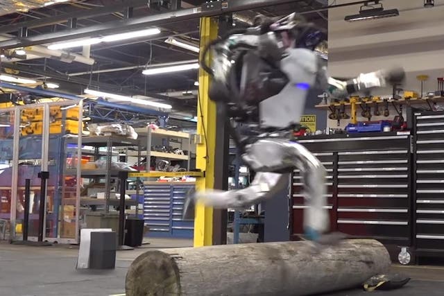 A still from the video showing the Atlas robot jumping over a log