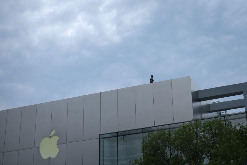 A worker stands on the roof of an Apple store in Beijing, China, on September 1, 2018