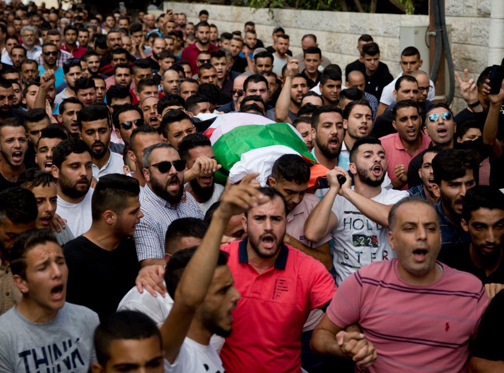 Palestinians carry the body of Aisha Rabi, 48, during her funeral in the West Bank village of Bidya