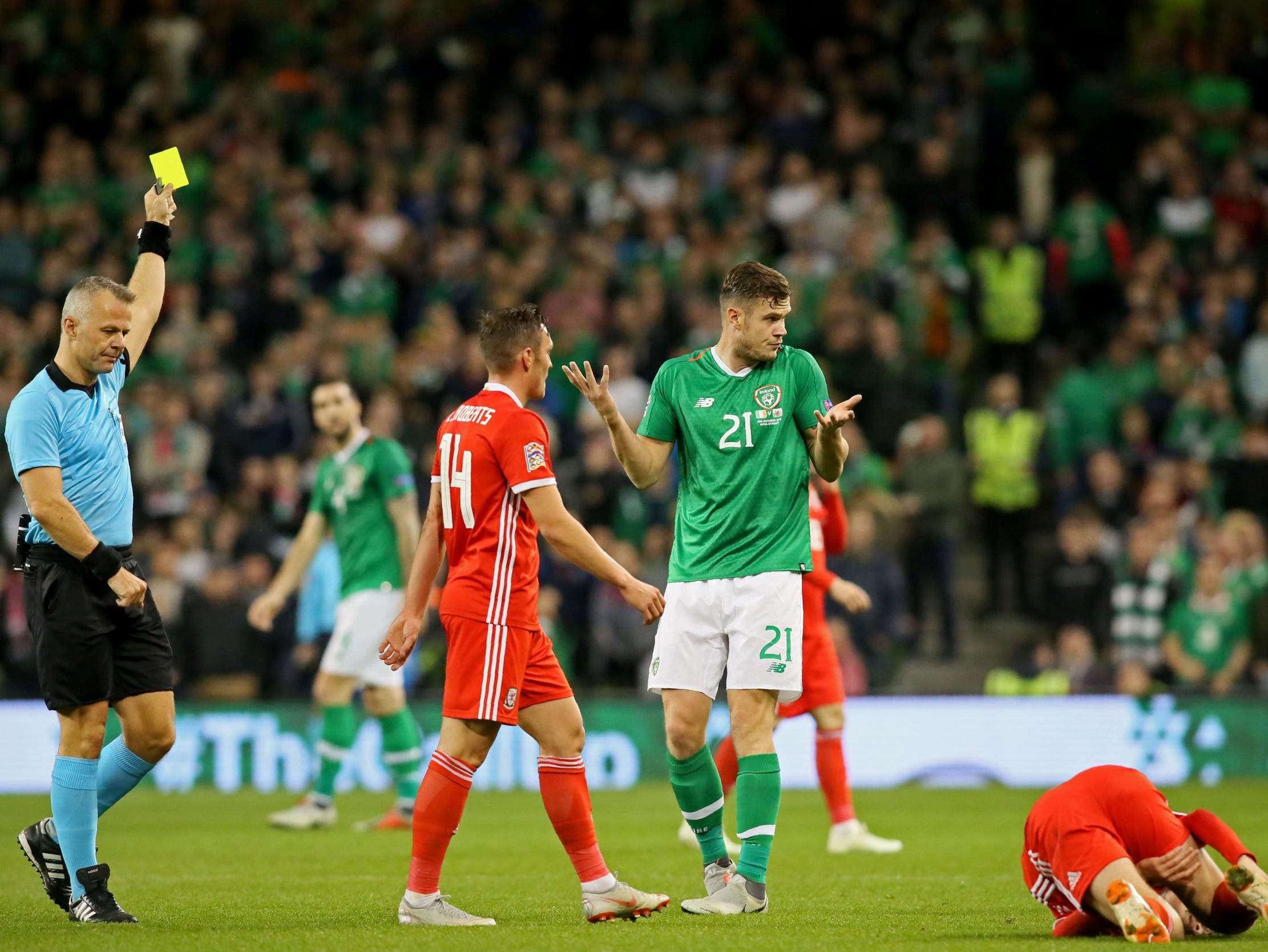 Kevin Long is shown a yellow card by referee Bjorn Kuipers