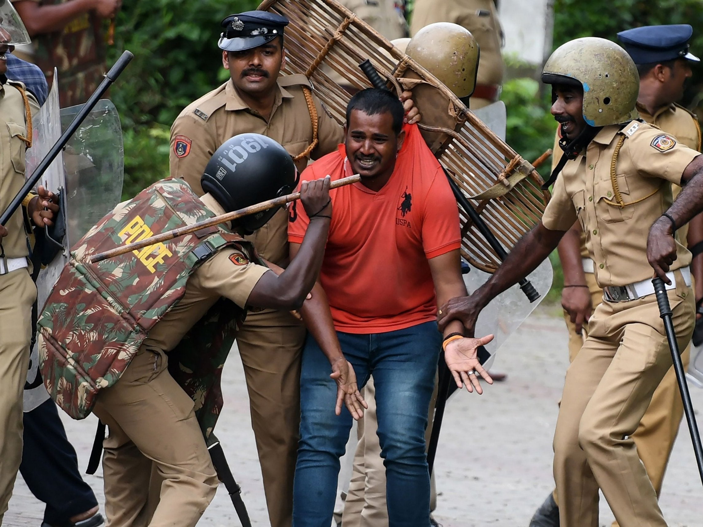 Indian police beat a Hindu activist as he pleads for his own safety as protesters rallied against a Supreme Court verdict revoking a ban on women's entry to a Hindu temple