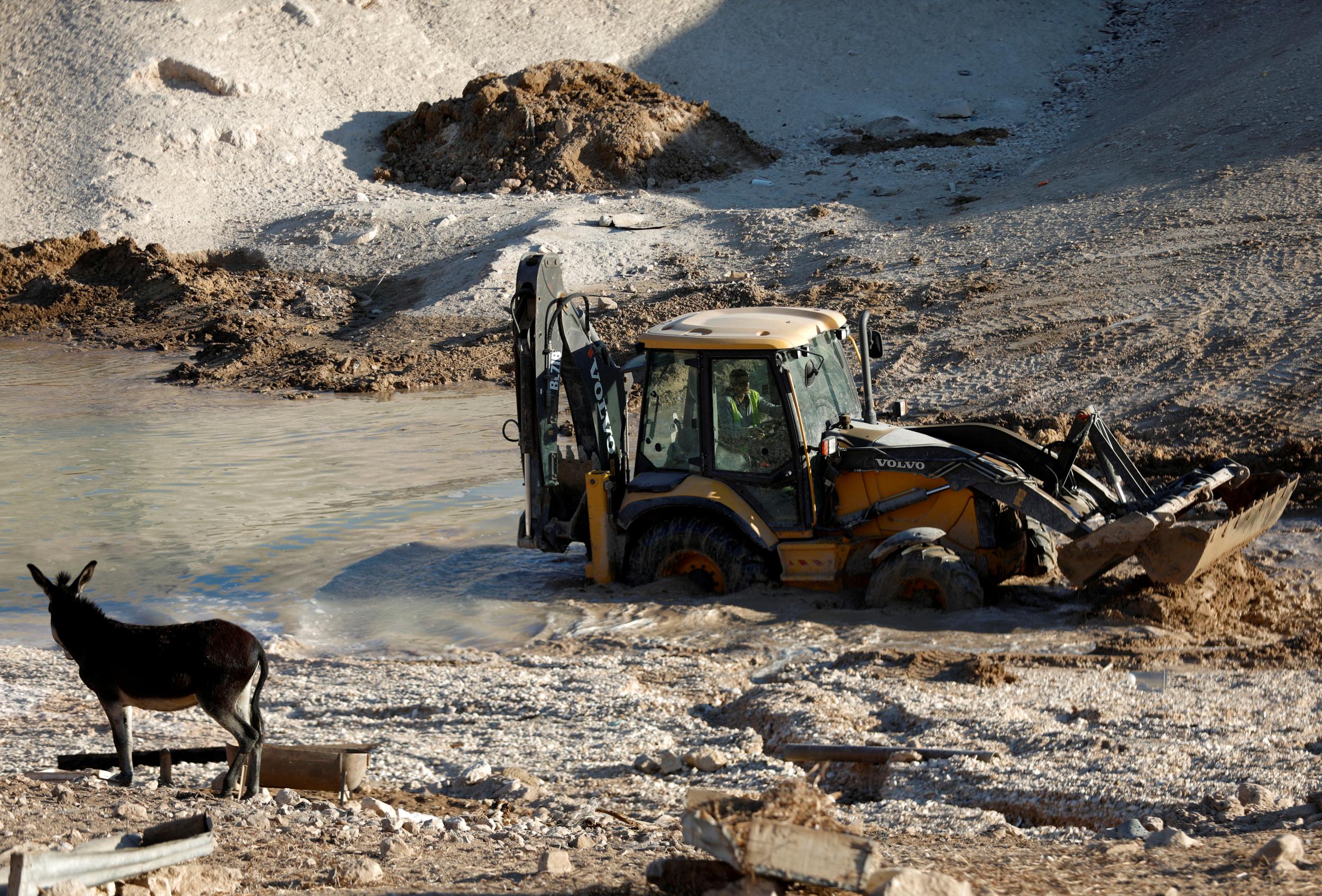 An Israeli bulldozer works on a wastewater pond in Khan al-Ahmar on October 16, 2018