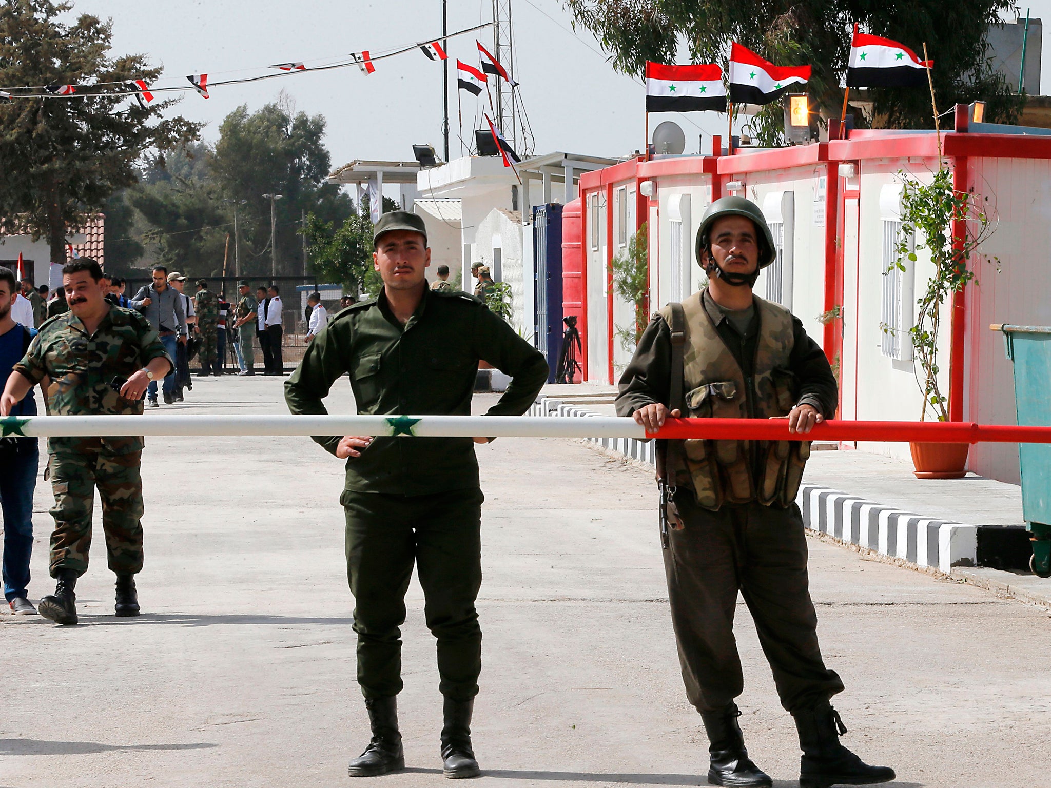 Syrian army officers guard their side of the Quneitra border crossing to the Israeli annexed-Golan Heights during its reopening
