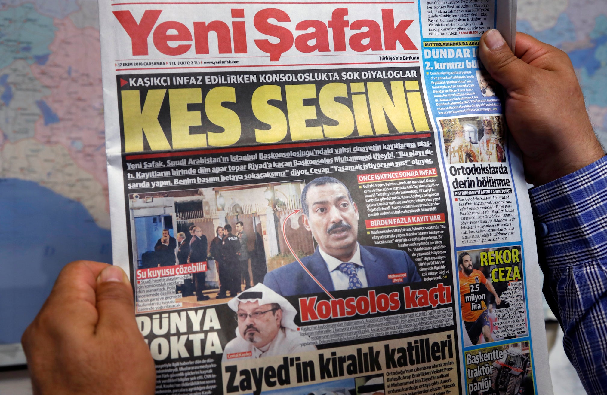 A man holds Yeni Safak newspaper with a headline that reads "(To the Saudi consul) Shut up."