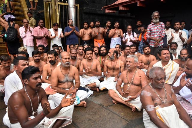 Hindu priests and temple staff sit on a protest against a ruling to let women of menstruating age entering Sabarimala temple