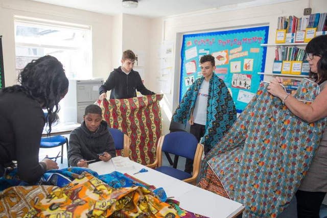 Students at Francis Barber Referral Unit in Wandsworth examine fabrics sent by children from Bangui