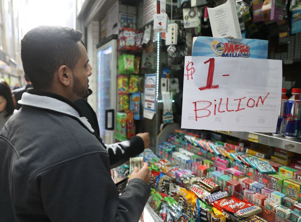 Customers line up to buy Mega Millions tickets at a newsstand in midtown Manhattan, New York