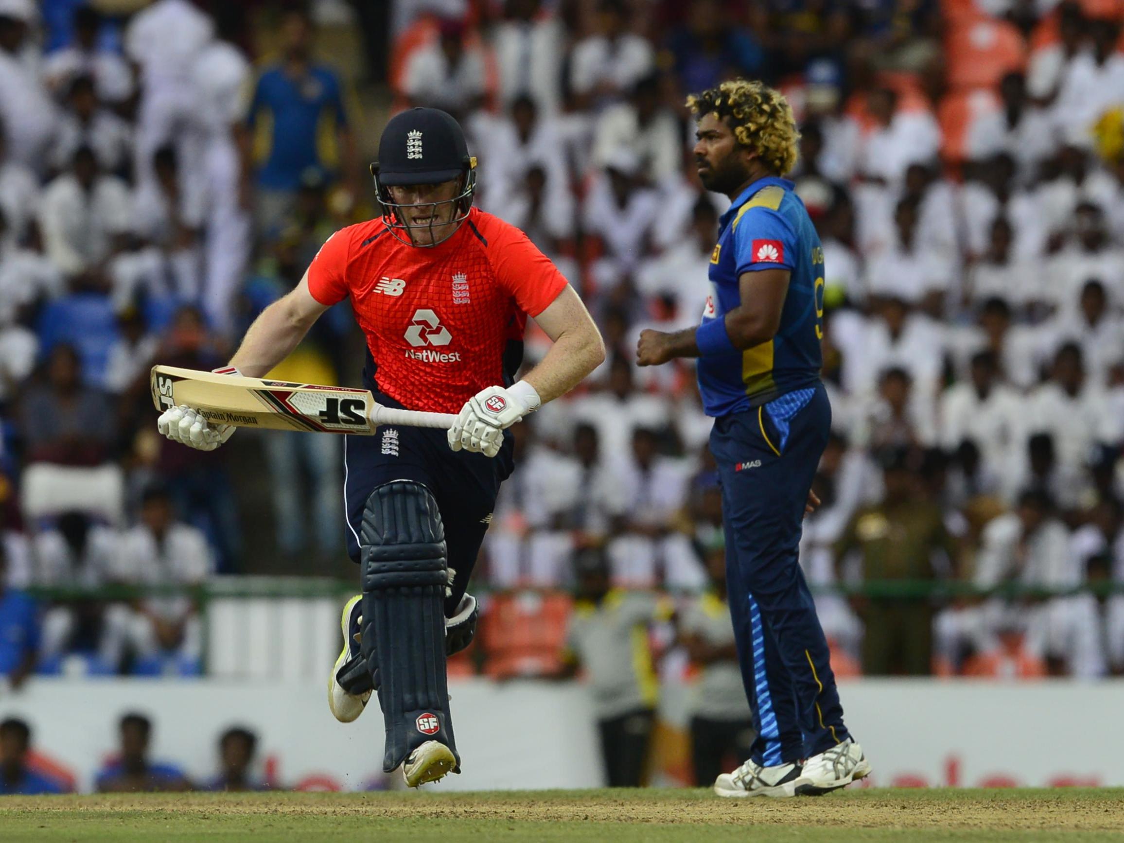 Eoin Morgan is watched by Lasith Malinga as he runs between the wicket