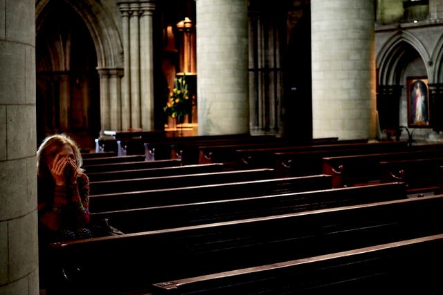 A woman during mass in Norwich cathedral