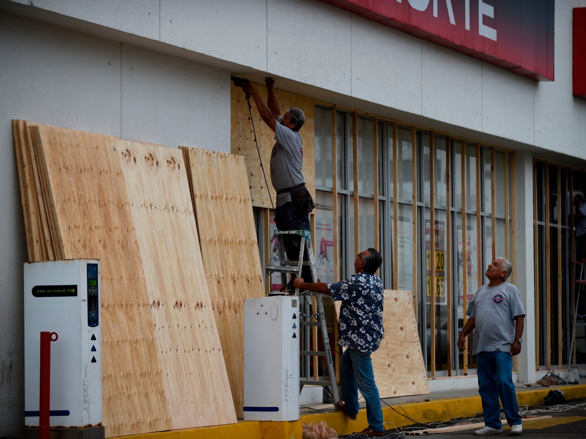 Workers protect a shop with wood panels in Mazatlan