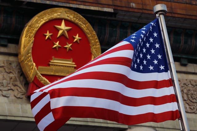 An American flag is flown next to the Chinese national emblem