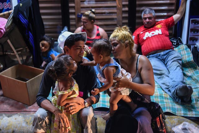 A Honduran migrant family taking part in a caravan heading to the US, rest on their arrival to Huixtla, Chiapas state, Mexico, on 22 October 2018.