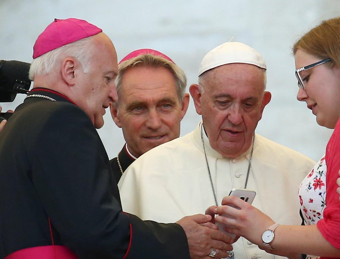 Pope Francis sends a message on a smartphone at the Vatican, July 31, 2018