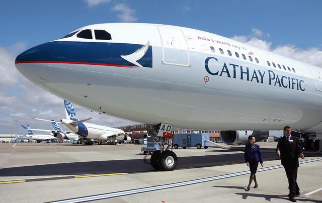 Two persons walk past an Airbus A330-300, the 100th plane delivered to Cathay Pacific, the Asian airline based in Hong-Kong