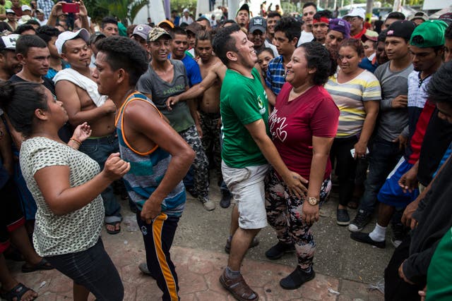 People dance at a makeshift camp organised by a caravan of Central American migrants traveling to the US
