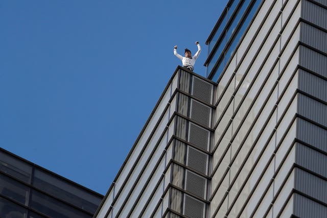 Alain Robert celebrates after climbing Heron Tower unharnessed